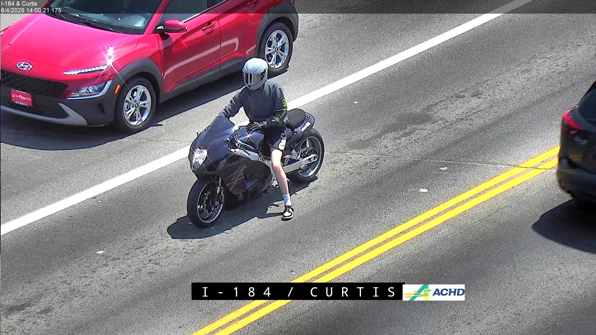 ISP seeks public assistance to help identify the motorcyclist who fled on I-84 - Black motorcycle stopped on roadway next to red car